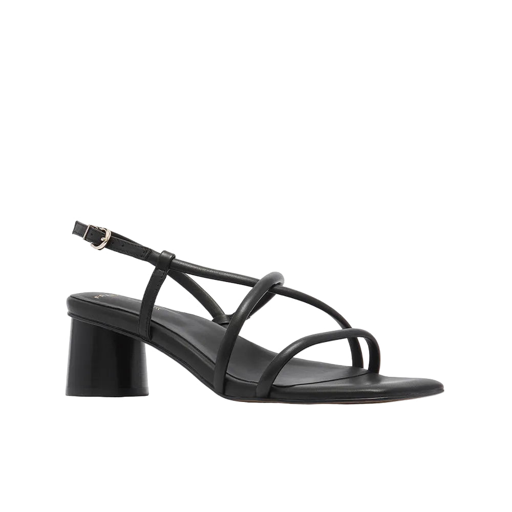 Black sandal with a block heel on a light beige background