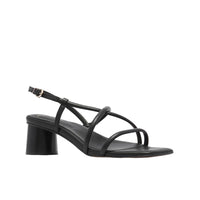 Black sandal with a block heel on a light beige background