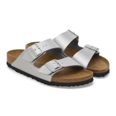 Pair of silver Birko-Flor Arizona sandals photographed at an angle, showing straps and cork-look midsoles