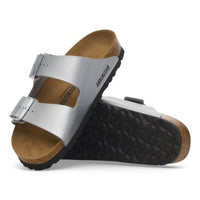 Silver Arizona sandals stacked, one upright and one tipped to show the patterned tread of the outsole